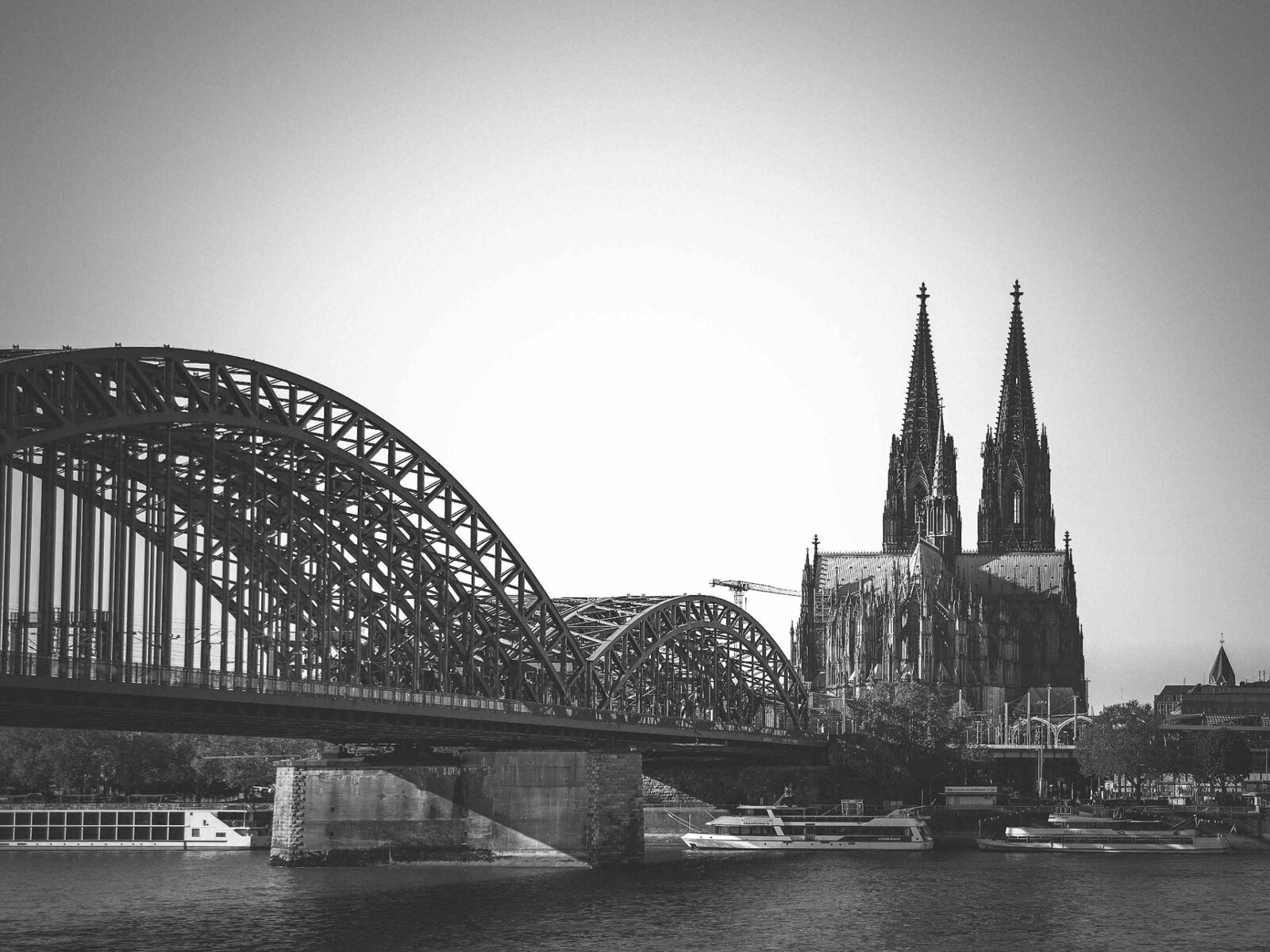 Kölner Dom und Hohenzollernbrücke über dem Rhein, Schwarz-Weiß-Aufnahme.